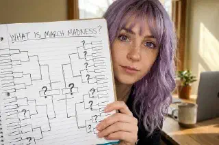 Close-up of an orange basketball with teal seams on a warm background