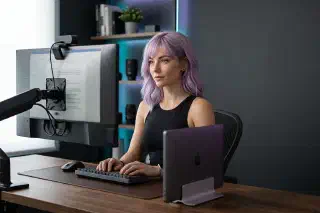 Mira at a streaming desk with a laptop, monitor, camera, and tidy capture setup